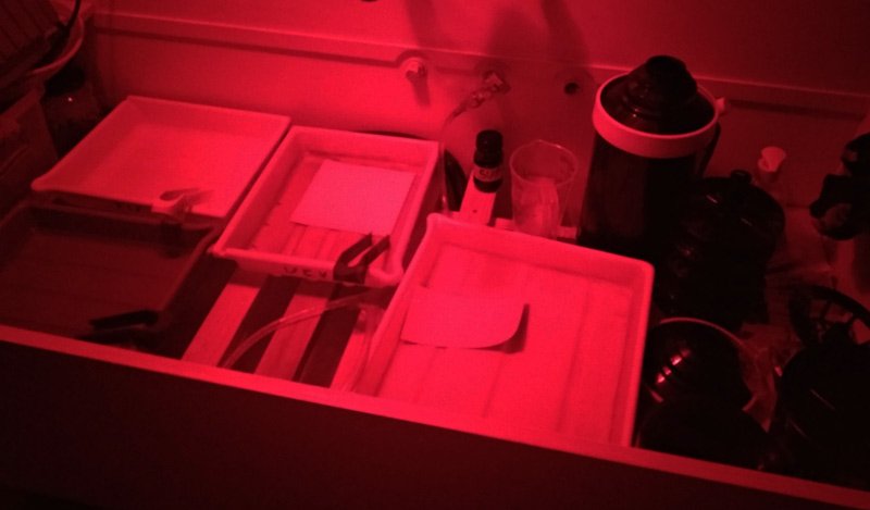Photographic darkroom print developing trays in a sink